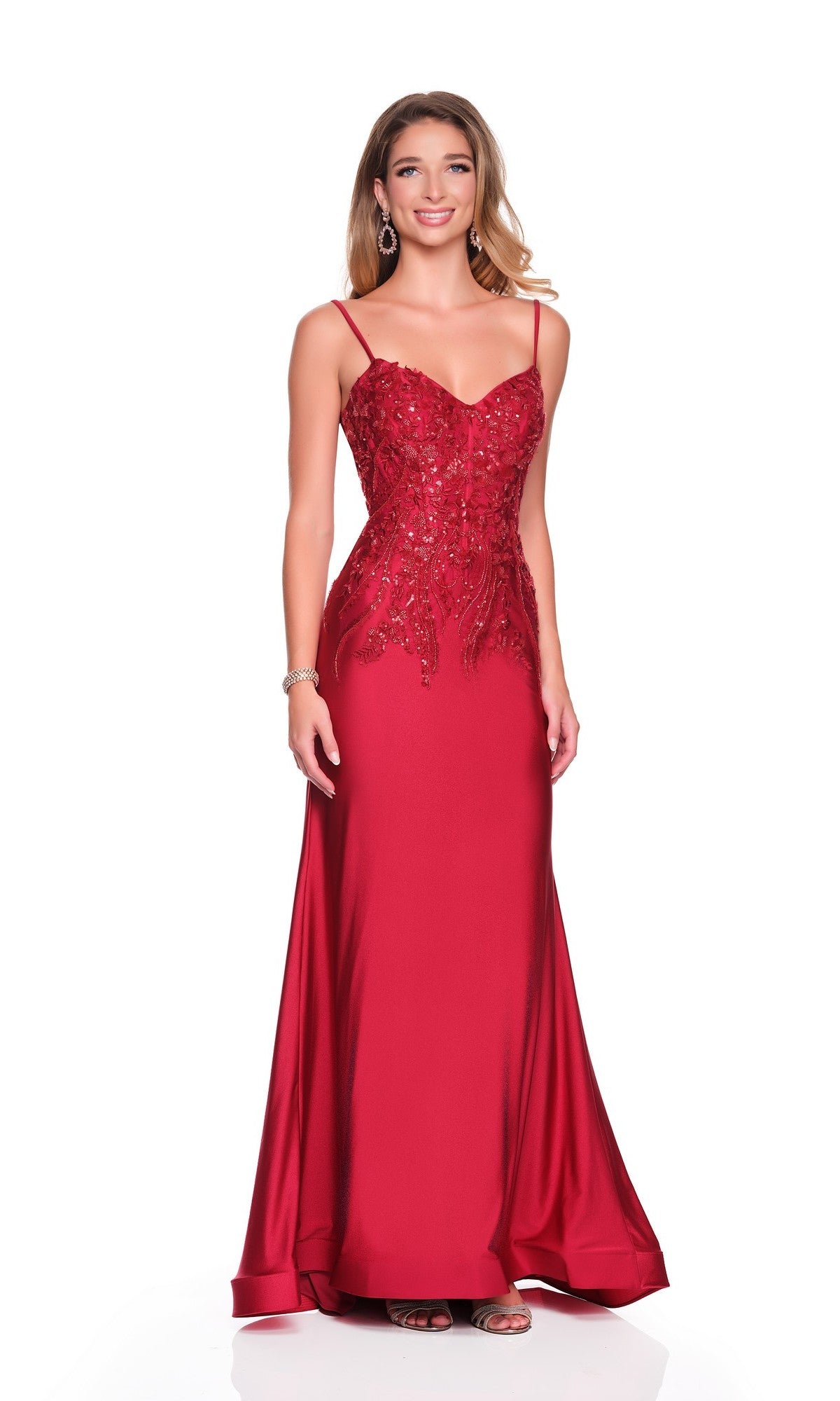 A woman stands against a white background wearing the Dave and Johnny 12881 long prom dress, featuring a dark red hue, sequin-embellished bodice, thin straps, and a slightly flared hem.